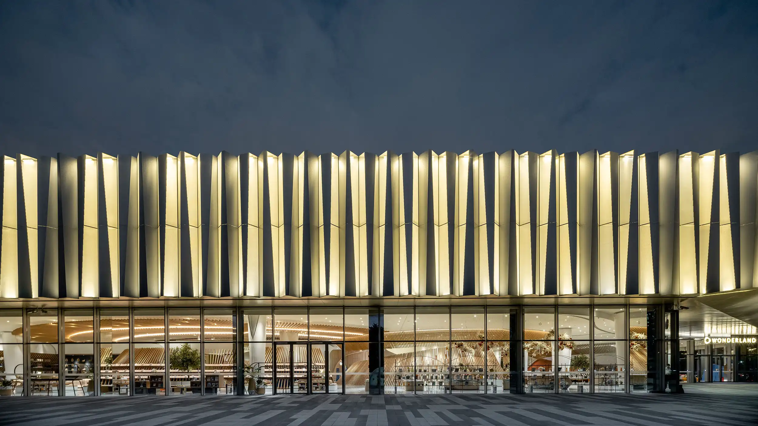 Aluminum Facade Materials: Simple 2026 Selection Guide Energy efficient aluminum facade with vertical metal fins and illuminated commercial building exterior
