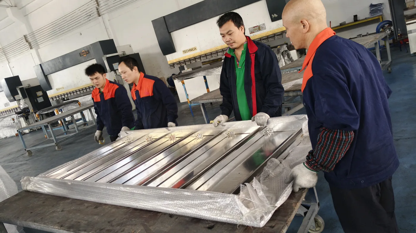 Aluminum Exterior Wall Panel Cost: 2026 Price Guide Likton Metal team handling finished aluminum curtain wall panels in Foshan workshop
