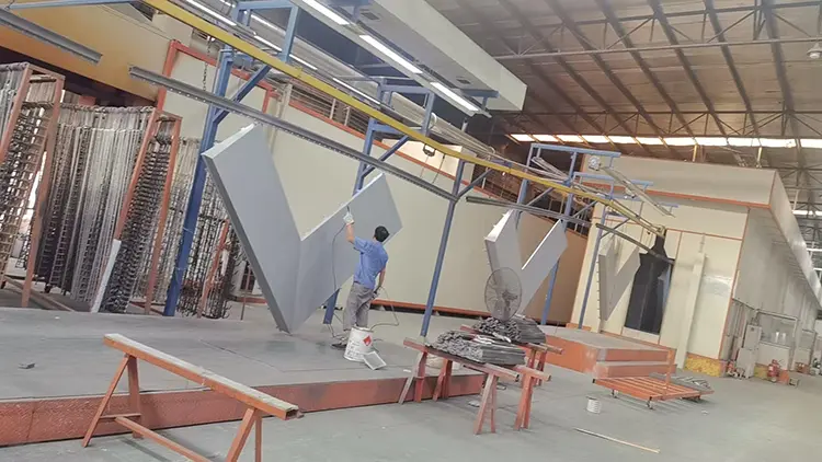 Commercial Aluminum Soffit Panels: Canopy Buying Guide Likton workshop worker beside large custom-formed aluminum components suspended for processing