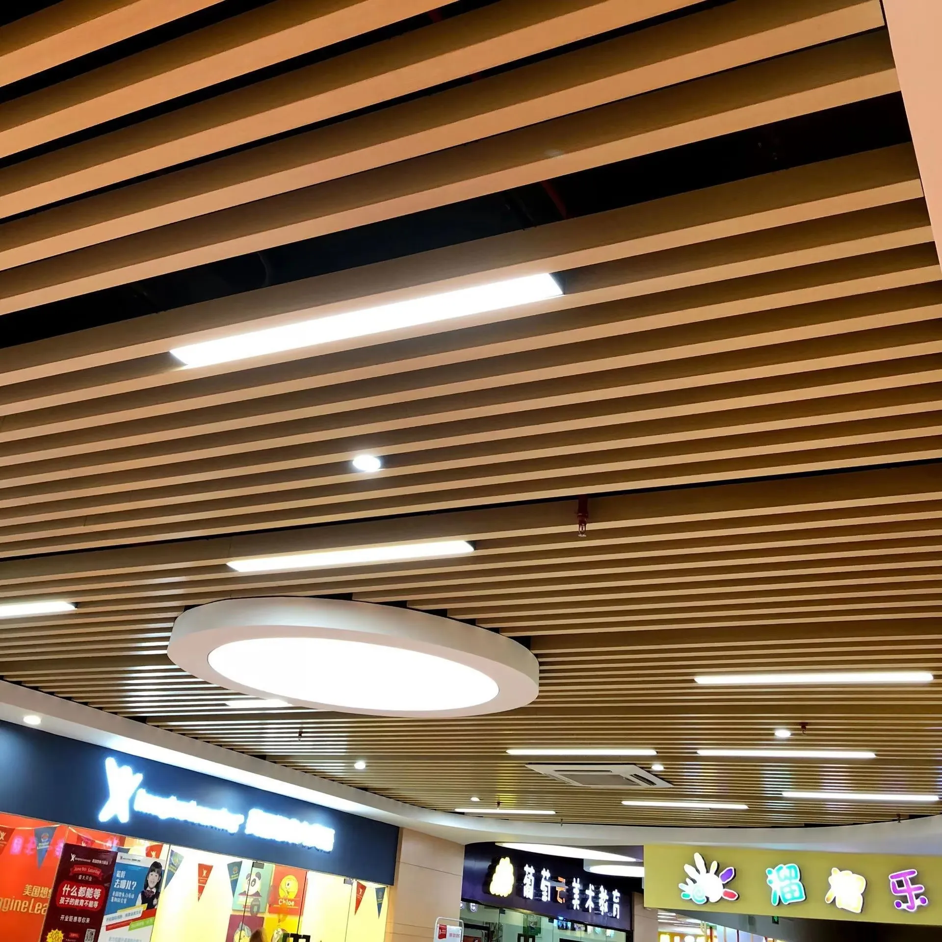 Home Linear wood-look ceiling baffles arranged around lights and an air-conditioning unit