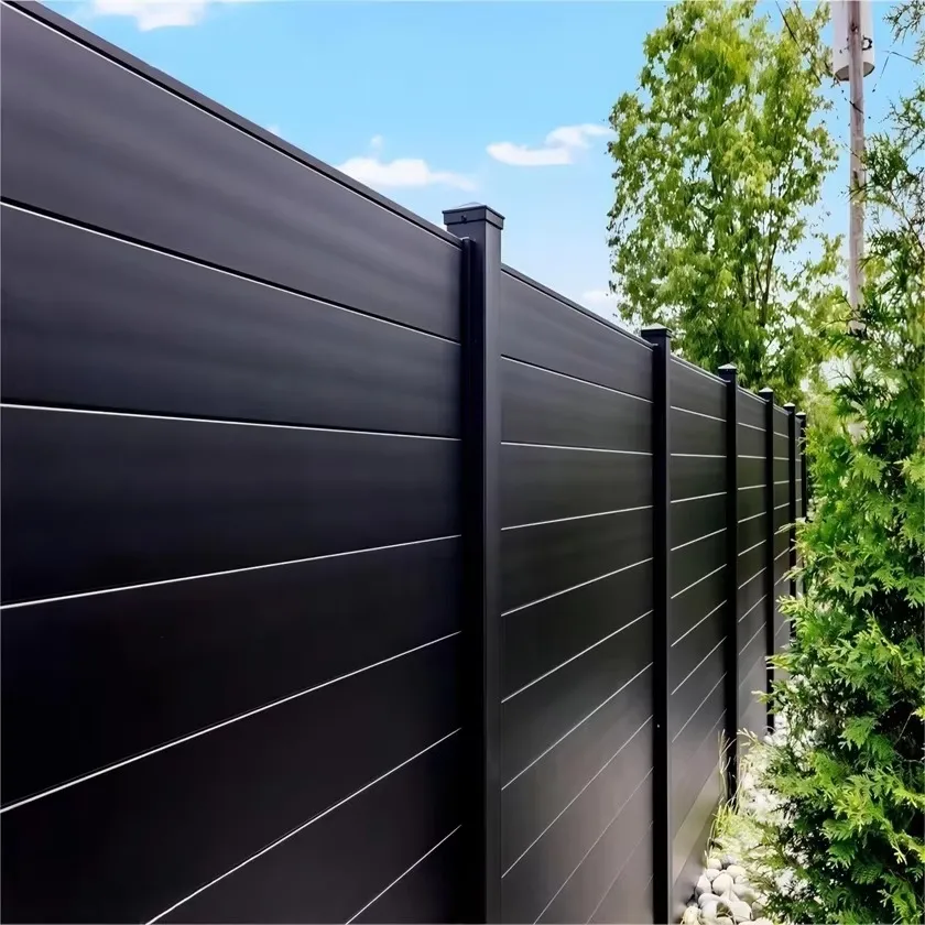Black aluminum privacy fence with horizontal slats in a garden