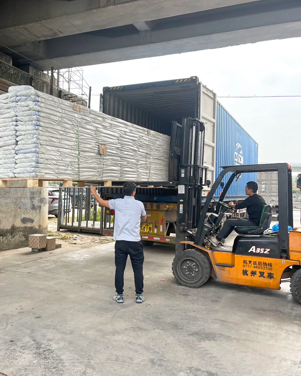 Forklift loading aluminum panels into a shipping container